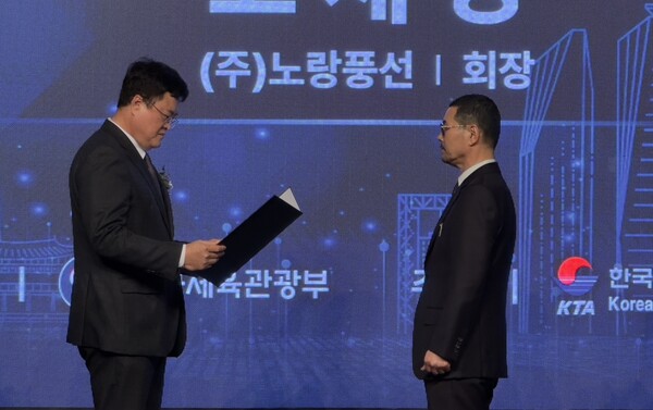 노랑풍선 고재경 회장(오른쪽)이 문화체육관광부 김대현 차관(왼쪽)에게 은탑산업훈장을 받고 있다 / 송요셉 기자